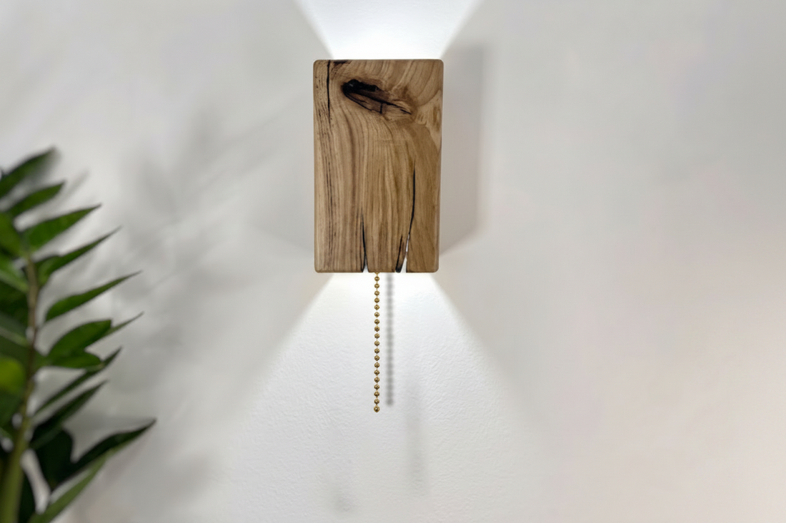 Wooden wall sconce with pull chain on a white wall