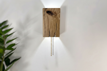 Wooden wall sconce with pull chain on a white wall