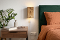 Two wooden wall sconces with electrical outlets on a white wall.